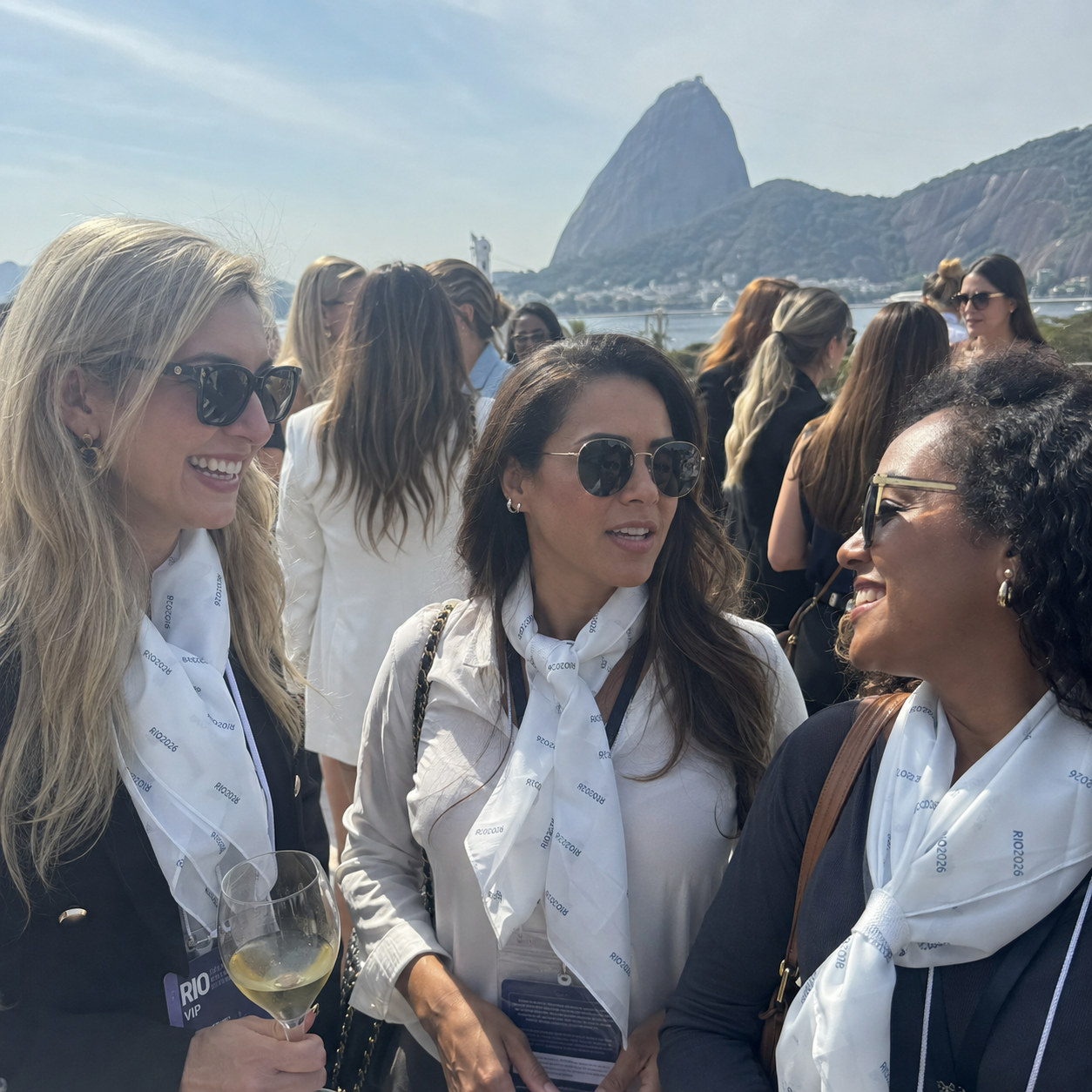 Mulheres usando lenço personalizado Rio 2026 em evento no Rio de Janeiro